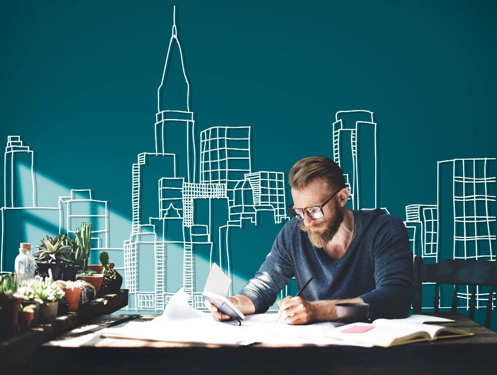 Person sketching architectural designs with a cityscape illustration in the background.